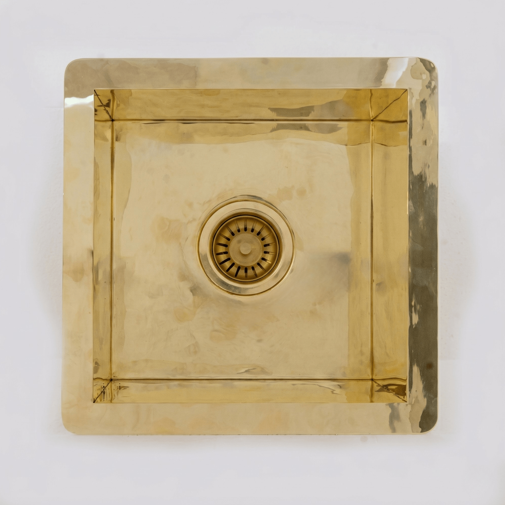 Solid unlacquered brass polished undermount sink — golden warm tone, kitchen island installation